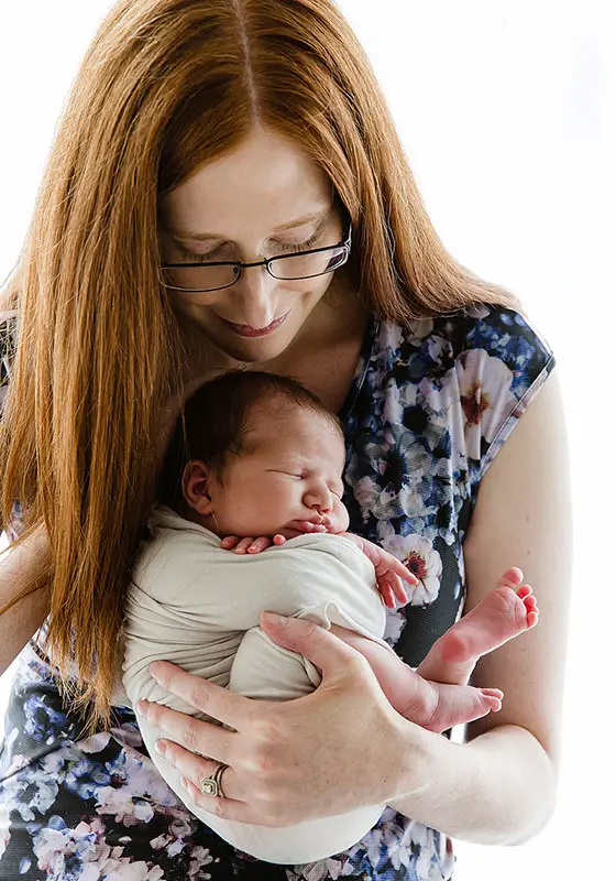 Mother in flower pattered dress for newborn family photo - an example of outfit choice for newborn photos.