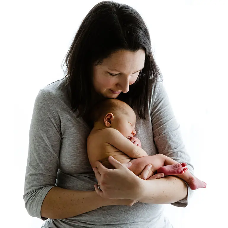 Newborn baby all curled up in Mummy's arms - Newborn Baby Photos by Vanilla Images.